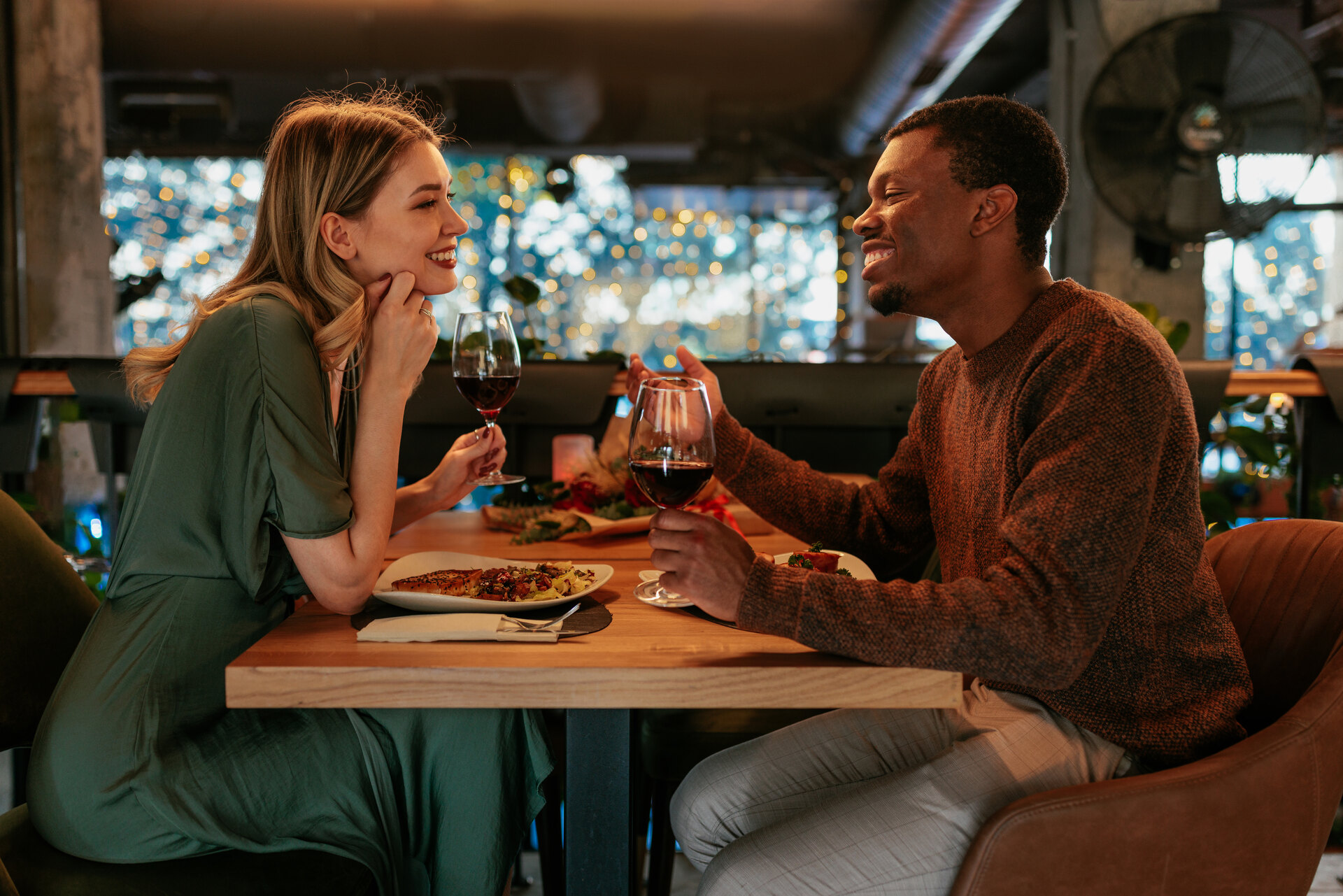 A happy young couple is on a Valentines day dinner date in a fancy restaurant.