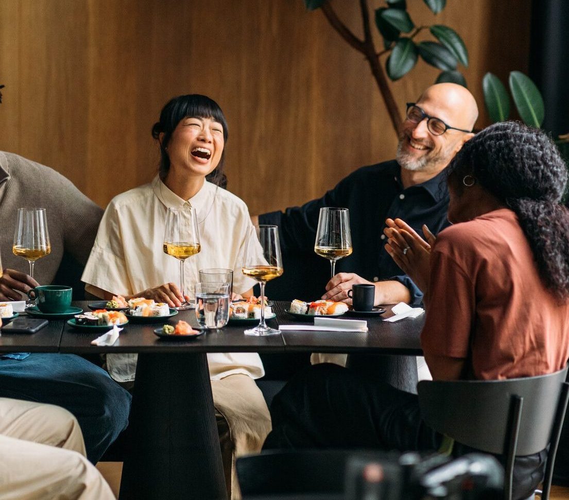 Multiracial friends laughing during brunch in restaurant